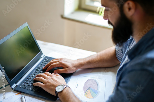 Successful businessman working in the office analyzing business data on notebook