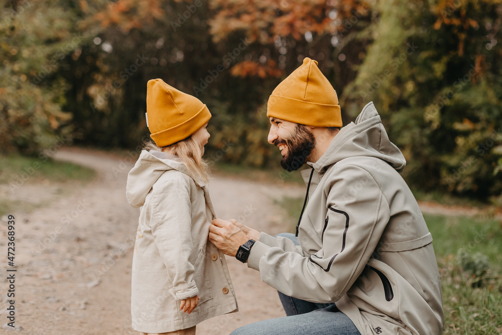 Happy father and daughter playing while walking in a beautiful autumn park. Ideal weekend father with his little daughter, autumnal mood Happy father and daughter playing while walking in a beautiful autumn park. Ideal weekend father with his little daughter, autumnal mood