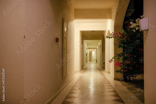 The corridor and arches of the white building is illuminated by
