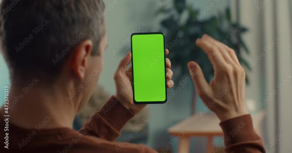 Man holding smartphone green screen during video call