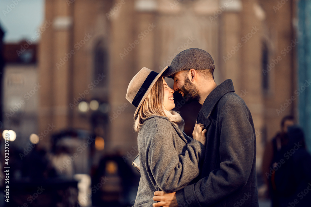 Romantic couple hugging outdoors. A young couple in love standing on the street, hugging and spending romantic moments together.