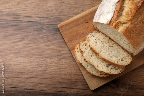 Cut tasty wheat sodawater bread on wooden table, top view. Space for text