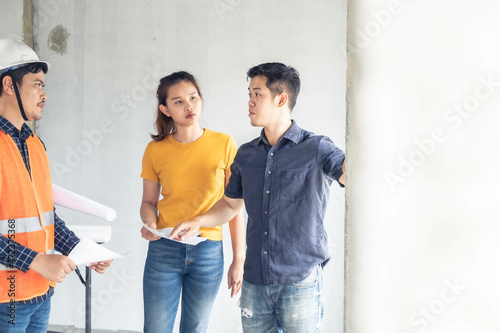 Young asian couple checking house with foreman engineering home inspection building house Walk home inspection with looking and pointing construction for check building home on job site construction