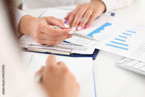 Female workers discussing working moments and check financial report