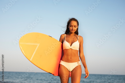  Fit girl preparing for the surf. Beautiful woman enjoy in sunny day © Jelena