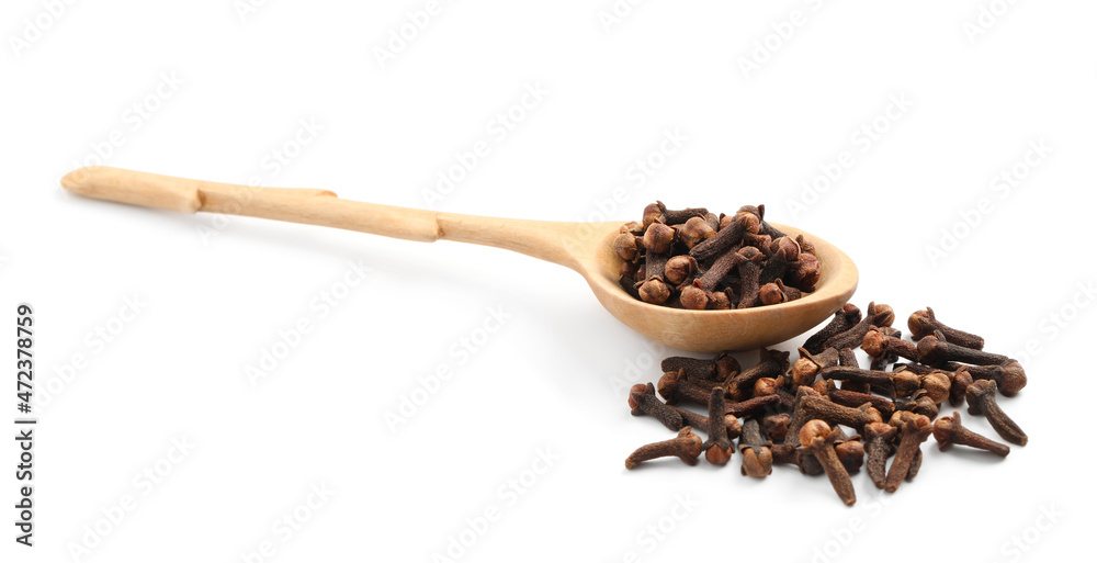 Pile of aromatic dry cloves and wooden spoon on white background Pile of aromatic dry cloves and wooden spoon on white background