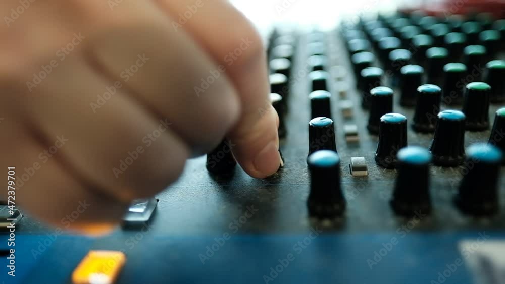 A slow motion close up video of an audio mixer console, with a hand getting in the shot to move the buttons. radio station, Israel. A slow motion close up video of an audio mixer console, with a hand getting in the shot to move the buttons. radio station, Israel.