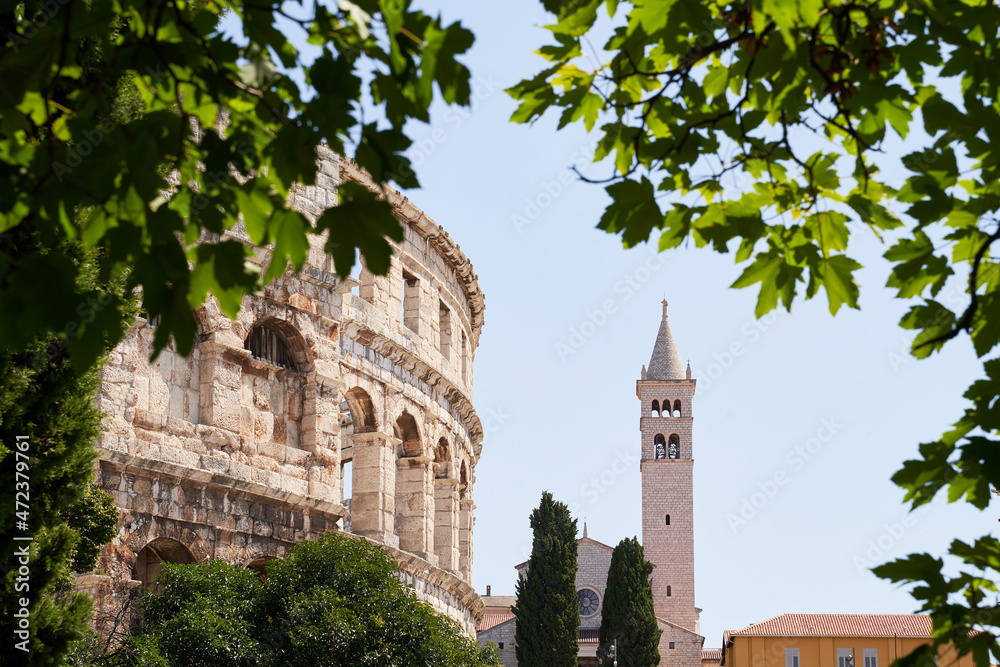 Pula, Croatia. Picturesque ancient Roman amphitheater arena and Saint Anthony church on a sunny summer day