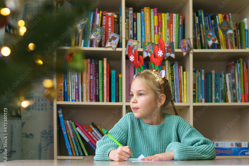 The sweet girl thought about the list of gifts for Santa. Writing a list of gifts for the holiday of Christmas and New Year. The sweet girl thought about the list of gifts for Santa. Writing a list of gifts for the holiday of Christmas and New Year.