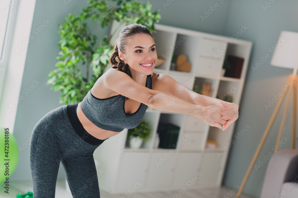 Photo of charming sweet young lady wear sport outfit smiling stretching practicing pilates indoors home house Photo of charming sweet young lady wear sport outfit smiling stretching practicing pilates indoors home house