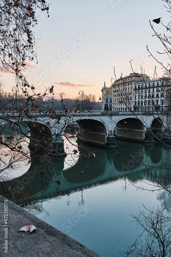 A bridge in Rome at sunset. Tevere river flows under it.