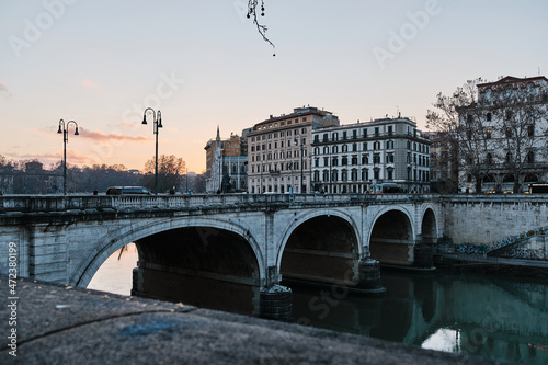 A bridge in Rome at sunset. Tevere river flows under it.