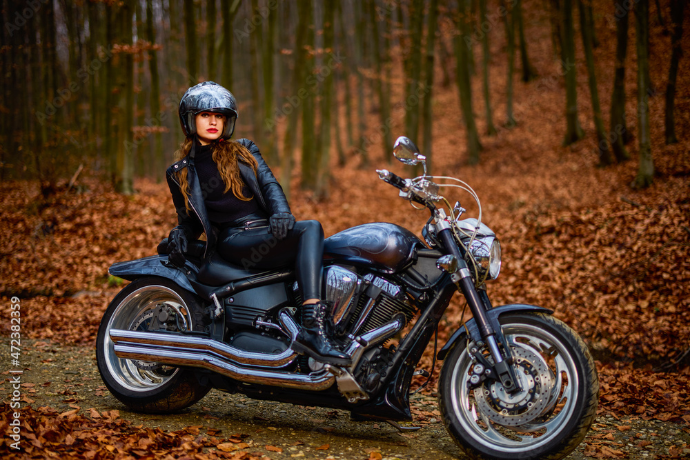 A beautiful woman with long hair on a chopper motorcycle in autumn landscape. A beautiful woman with long hair on a chopper motorcycle in autumn landscape.