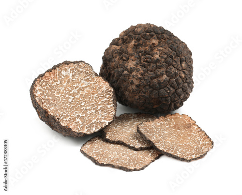 Cut and whole black truffles isolated on white