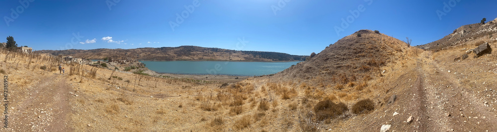 panorama photo background, view of the abandoned Turkish village of Finikas with the ruins of houses on the banks of the reservoir in Cyprus, Paphos