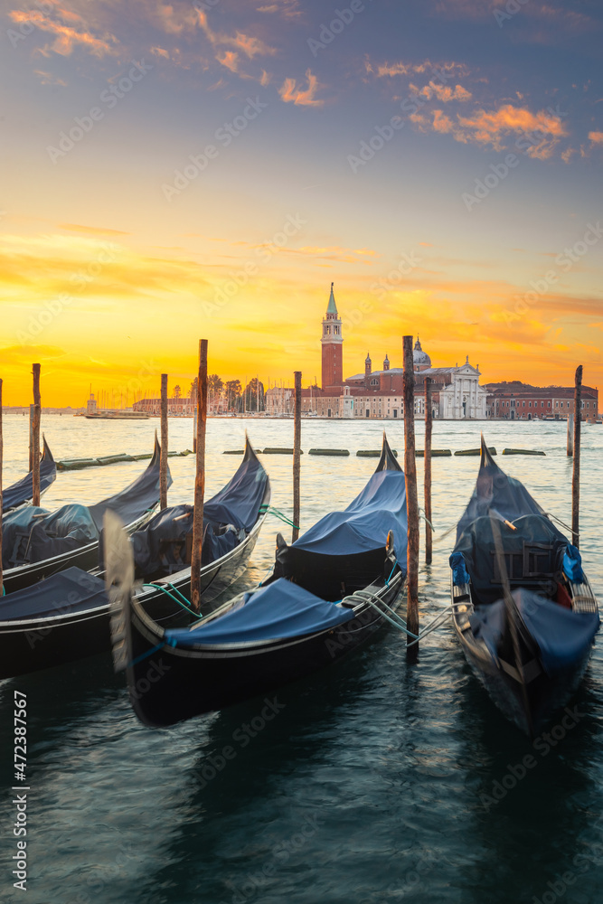 Gondolas parked at Venezia with San Giorgio Maggiore church at the back while sunrise, Veneto, Italy.