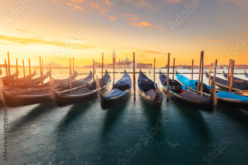 Gondolas parked at Venezia with San Giorgio Maggiore church at the back while sunrise, Veneto, Italy..