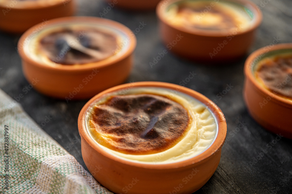 Rice pudding dessert cooked in a clay pot in the oven. Ready to serve on black presentation board