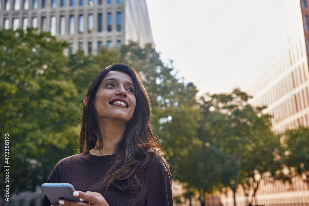 Fototapeta premium Smiling businesswoman with mobile phone on street