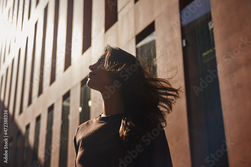 Young businesswoman standing on sunny street