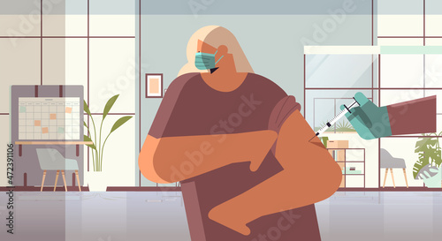 doctor hand vaccinating female patient in medical mask fight against coronavirus vaccine development concept