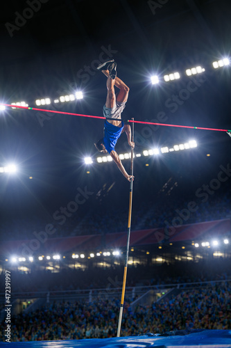 Photography Pole Vault Jumping: Professional Male Athlete on World Championship Successfully Jumping with Pole over Bar