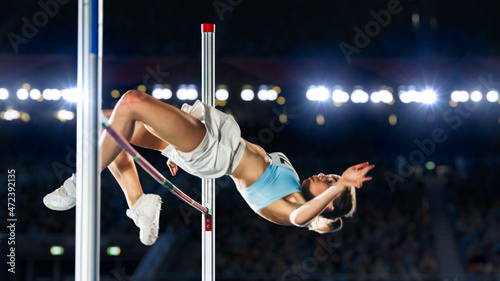 High Jump Championship: Professional Female Athlete on World Championship Successfully Jumping over Bar. Shot of Competition on Stadium with Sports Achievement Experience. Determination of Champion.