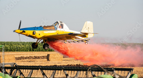 low flight of agricultural propeller plane is spraying crop protection products.