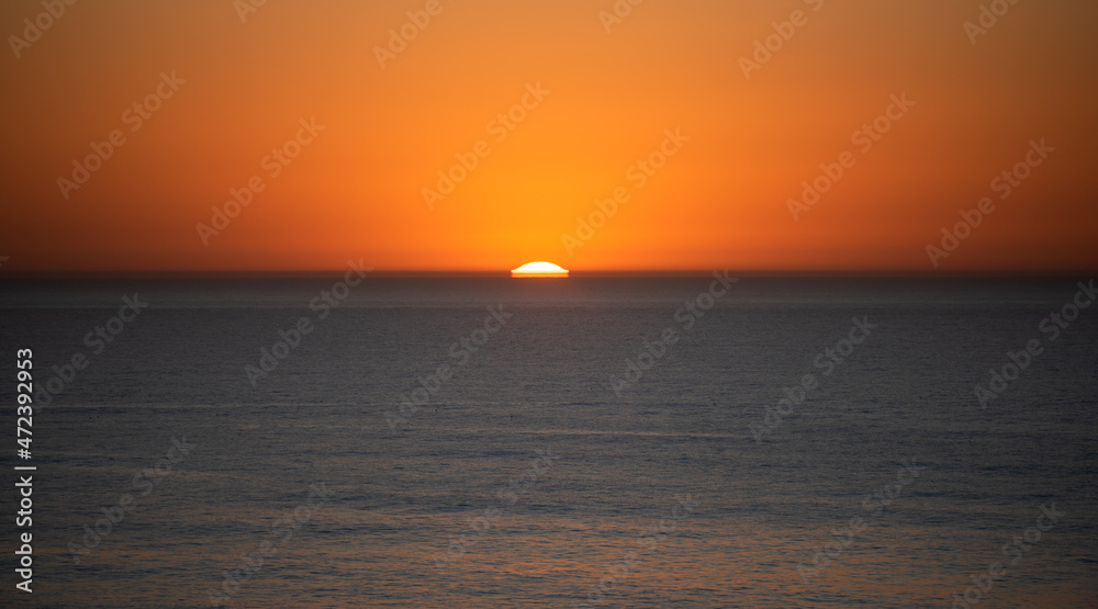 sunset in the sea with some distortion of the sun