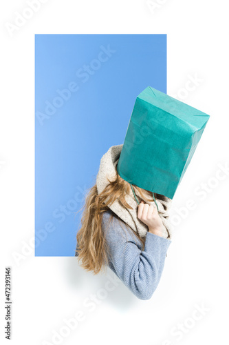 Woman covering the head wigh a shopping bag. Shopaholic and shopping addiction concept photo