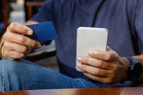 Man using smartphone payment by credit card shopping online outdoors