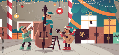 elves with musical instruments santa helpers team playing guitar and trumpet happy new year christmas holidays celebration