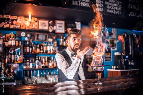 Professional mixologist decorates colorful concoction at the nightclub photo