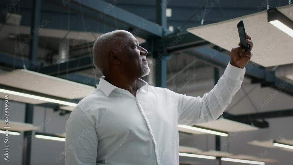 Middle Aged Black Businessman Capturing Video With Smartphone In Modern Business Center Interior