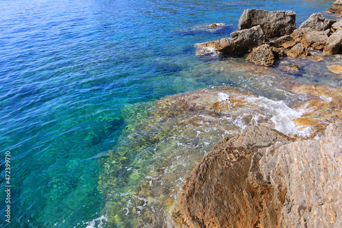 Top view of clear blue water and stones by the sea