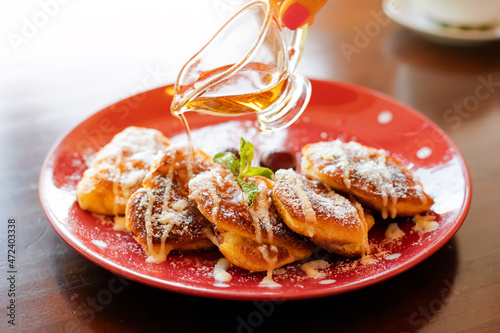 maple syrup is poured on sweet pancakes. Delicious dessert with an overabundance of fast carbohydrates and sugar