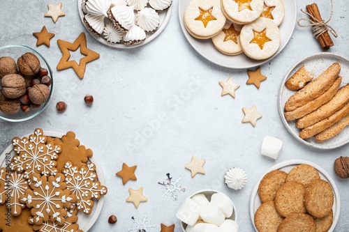 Tasty homemade cookies, marshmallows and meringue on gray background. Christmas and New Year concept. Gingerbread, austrian linzer cookies, biscotti. Top view, holidays flat lay. Copy space.