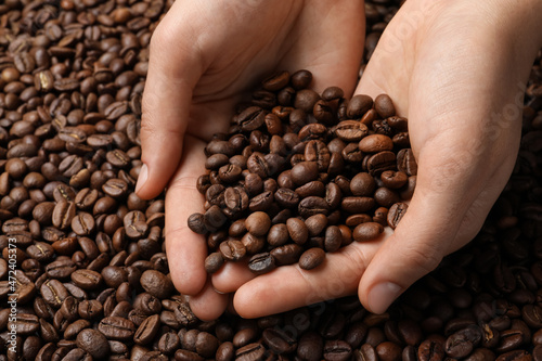 Woman with roasted coffee beans  closeup view