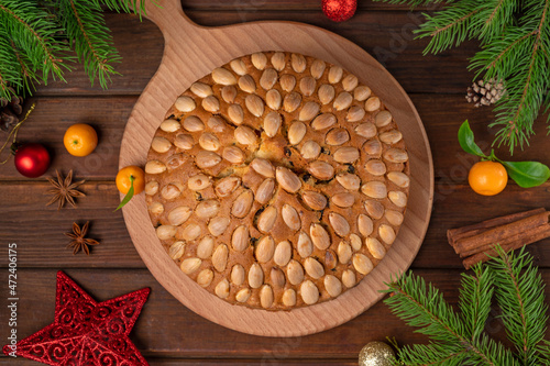 Traditional Christmas Dundee cake with dried fruits and almonds on a wooden board. Festive dessert. Rustic style, selective focus photo