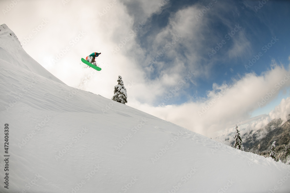 Great view of snowy mountain slope and snowboarder jumping air