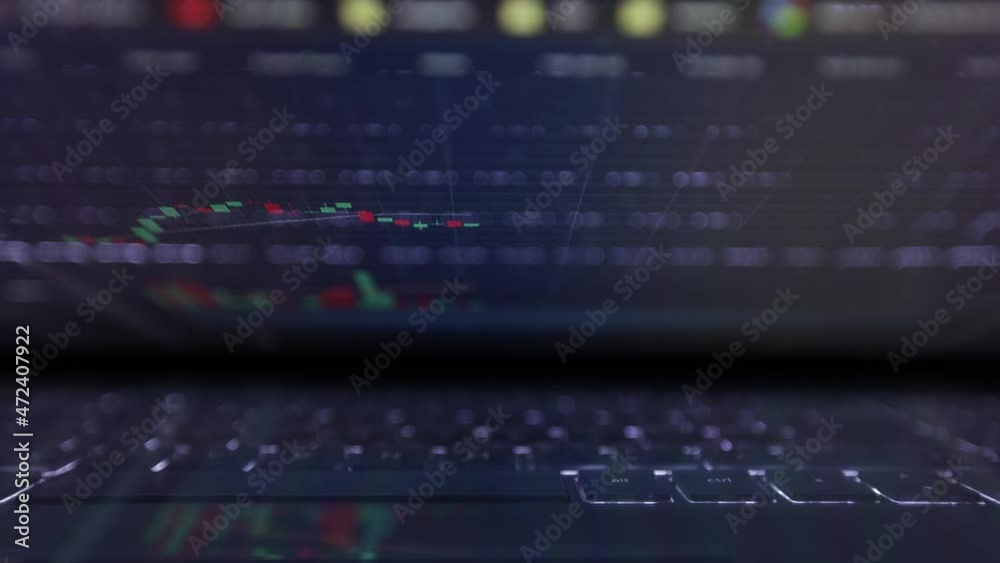 Laptop screen with stock market charts. Technical analysis and fundamental indicators of stock quotes in the trading terminal. Japanese candlesticks and company tickers.