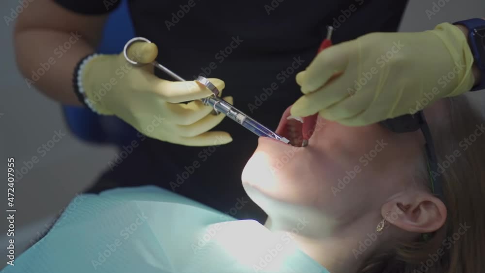 real .dentist injects an anesthetic into patient before tooth