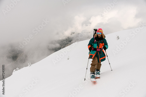 front view of smiling man skier walking along snowy hill trail