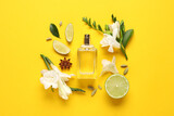 Flat lay composition with bottle of perfume and fresh citrus fruits on yellow background