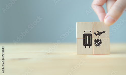 Travel safety and travel insurance concept ;wooden cube with grey background, copy space. Intended to cover medical expenses, trip cancellation, lost luggage and other losses incurred while traveling.