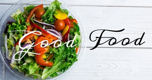 Overhead view of good food text over fresh salad in bowl on wooden table