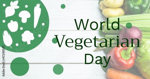 Overhead view of world vegetarian day text by fruits and vegetables on table