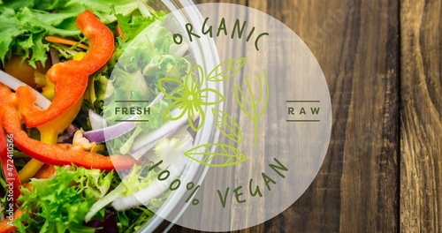 Directly above view of organic 100 percent vegan symbol text over fresh salad in bowl on table