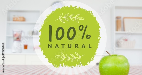 Close-up of 100 percent natural symbol sign by fresh granny smith apple on table