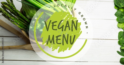 Close-up of locally grown vegan menu over fresh vegetables on wooden table